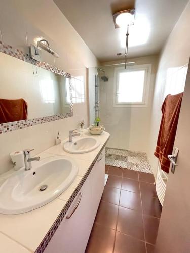 une salle de bain avec deux lavabos et un miroir dans l'établissement Maison Bellevue, à Fumel