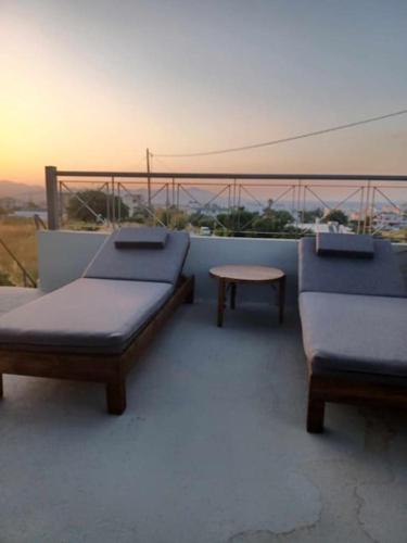 two beds and a table on top of a roof at Marias Guest House in Zipárion