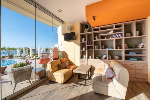 a living room with couches and a large window at Aphrodite Beach Hotel in Nesebar