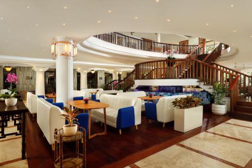 een restaurant met tafels en stoelen en een trap bij Bali Dynasty Resort in Kuta