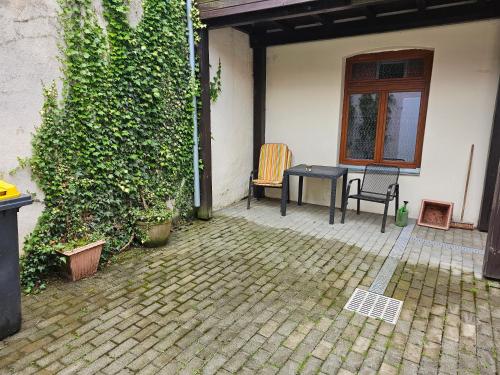 a patio with a table and chairs next to a building at Ferienwohnung Gräfin Cosel in Stolpen