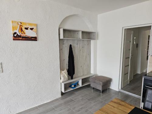 a living room with a shelf and a chair at Ferienwohnung Gräfin Cosel in Stolpen
