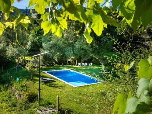 a swimming pool in the yard of a house at QUINTA do SOUTO BARCIADEMERA in Barciademera