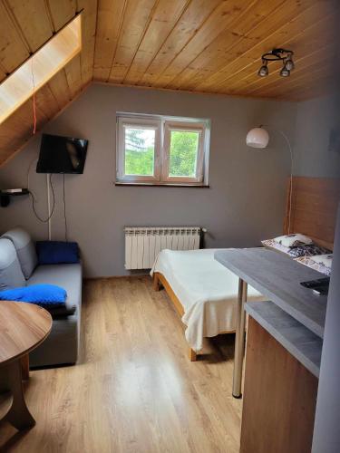 a small room with a bed and a table at Jelonek Zawoja in Zawoja