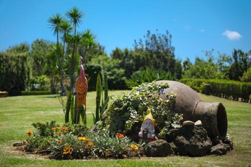 een tuin met een olifantenbeeld en bloemen bij Quinta Morazes Casas de Campo in Ribeira Grande