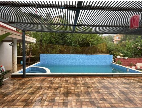 a pool with a blue bench in a backyard at Dream Valley Resort and Farmhouse, Mahableshwar in Mahabaleshwar
