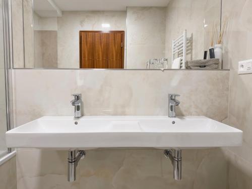 a white sink in a bathroom with a mirror at Hotel Cvilín in Krnov