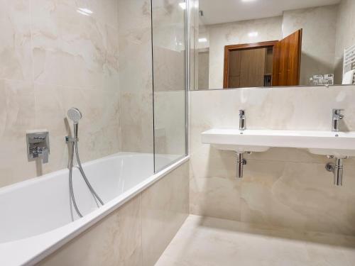 a bathroom with a tub and a sink and a shower at Hotel Cvilín in Krnov