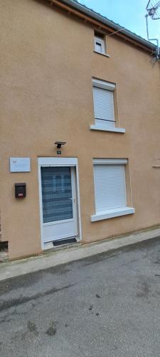 a building with two windows with blinds on it at Maison de bourg in Jumeaux