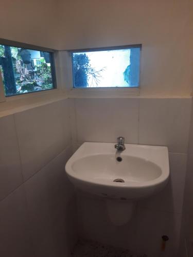 a bathroom with a sink and two windows at Airport Hostel Manila in Manila