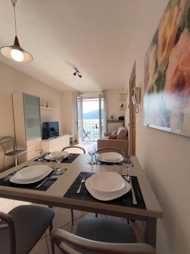 a living room with a table with plates and chairs at On the Lake in Bellano