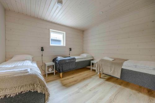 a room with two beds and a window at Luksushuvila Villa Helmi in Himos