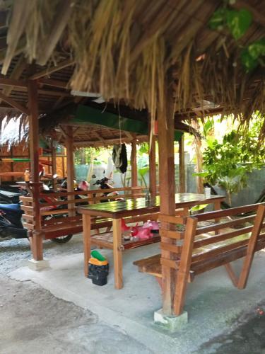 a restaurant with benches and a thatched roof at Weeroona Huts Homestay Pacifico in San Isidro
