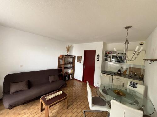 un salon avec un canapé et une table en verre dans l'établissement Au centre ville de la Grande Motte, à 200m de la plage N68, à La Grande Motte