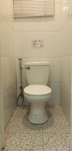 a bathroom with a white toilet in a room at Airport Hostel Manila in Manila