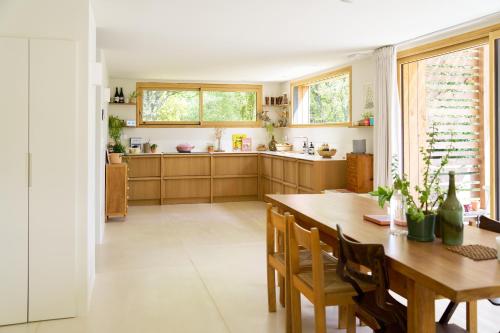 une grande cuisine avec une table et des chaises en bois dans l'établissement La Grande Josy, à Fouesnant