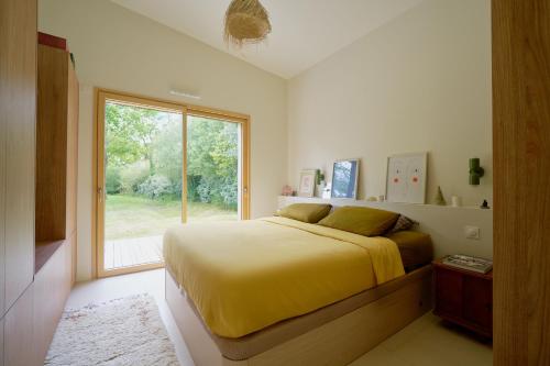 une chambre avec un lit jaune et une fenêtre dans l'établissement La Grande Josy, à Fouesnant