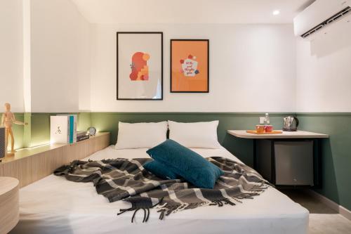 a bedroom with a bed with a blue pillow on it at Upstairs Downstairs CoLiving Bukit Bintang in Kuala Lumpur