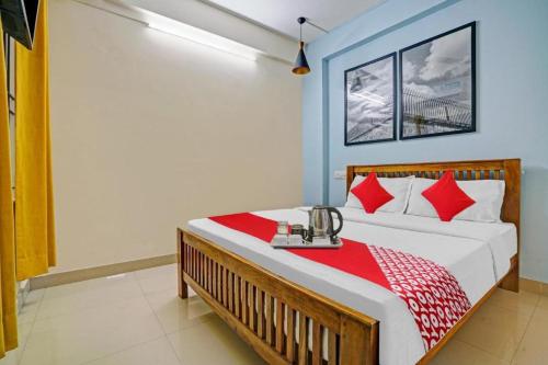 a bedroom with a bed with red and white pillows at Ruby Hotel Apartments in Kakkanad