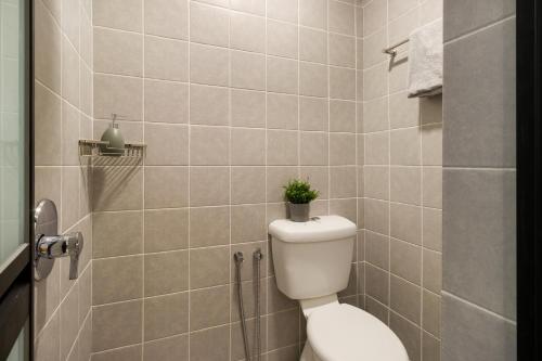 a bathroom with a toilet with a plant on it at Upstairs Downstairs CoLiving Bukit Bintang in Kuala Lumpur