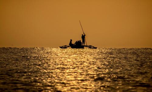 two people in a boat on the water at sunset at Mahali Zanzibar in Paje