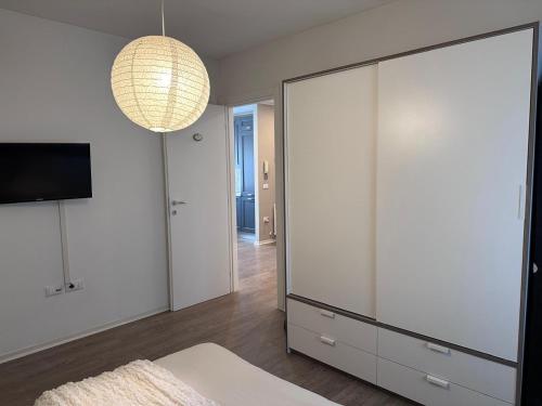a living room with a large white closet and a large mirror at A cjase di Luca in Paluzza