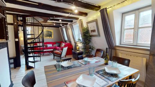 un salon avec une table et un canapé rouge dans l'établissement La Grande Ourse, à Colmar