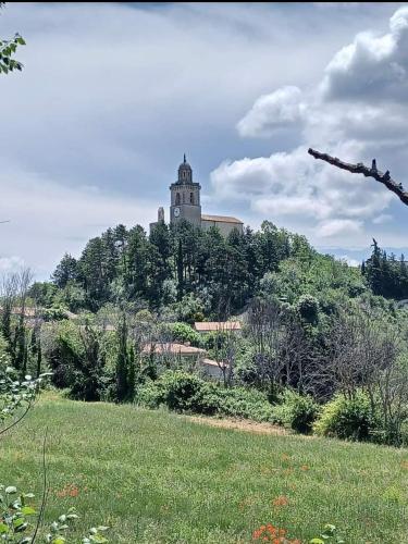 un bâtiment au sommet d'une colline avec un champ dans l'établissement Coeur de Reillanne, à Reillanne