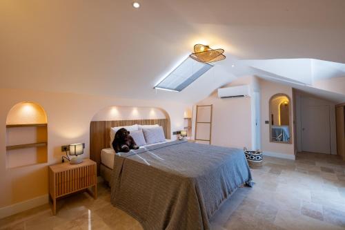 a bedroom with a bed with a dog sitting on it at Hotel Club-E in Fethiye