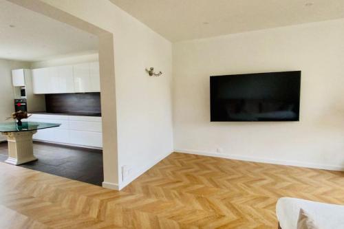 un salon avec une grande télévision à écran plat au mur dans l'établissement Maison - 6 personnes, à Nanterre