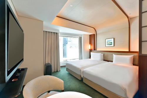 a hotel room with a bed and a television at Marunouchi Hotel in Tokyo