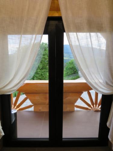 a window with curtains and a view of the ocean at Bucovina Exclusiv in Vama