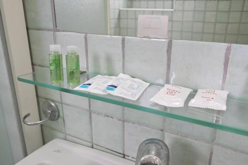 a glass shelf above a sink in a bathroom at Av Isola Verde Hotel Thermal Spa in Ischia