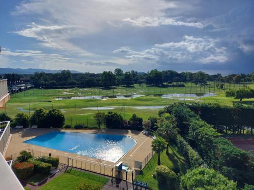 - une vue sur la piscine sur un parcours de golf dans l'établissement Nausicaa T2 climatisé piscine - Axelle Loc'Appart, à Mandelieu-la-Napoule