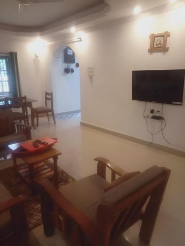 a living room with a flat screen tv on a wall at Ronne's Casa De Piscina Privada 3BHK VILLA in Verla
