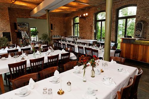a dining room with white tables and chairs at Seminar- und Gästehaus Flussbad Gartenstrasse in Berlin