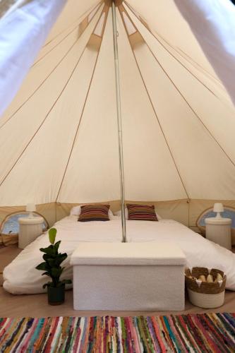 - un lit dans une tente avec un matelas blanc dans l'établissement Wild Lodge, à Lasséran