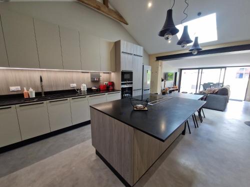 une grande cuisine avec une grande île au milieu dans l'établissement Maison au calme et avec le charme de la pierre, gite 