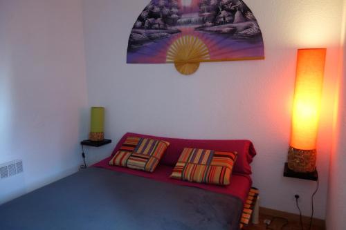 une chambre avec un canapé rouge et deux lampes dans l'établissement La BALEINE ROSE, au Cap d'Agde