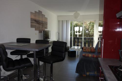 un salon avec une table et des chaises dans l'établissement La BALEINE ROSE, au Cap d'Agde