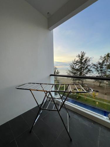 a glass table in a room with a window at SS Staycation 2 Roxy Sematan Beach Apt in Sematan