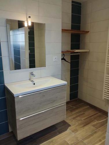 une salle de bain avec un lavabo et un miroir dans l'établissement La Ferme d'Adèle, à Tence