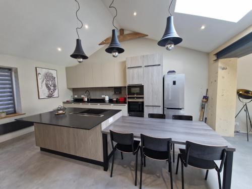 une cuisine avec une grande île et des chaises dans l'établissement Maison au calme et avec le charme de la pierre, gite 