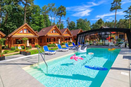 a home with a pool and a house at Bajkowe Domki in Pobierowo
