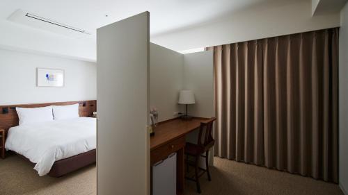 a hotel room with a bed and a desk at Shin-Osaka Station Hotel in Osaka