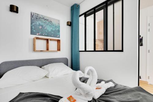 - une chambre avec 2 cygnes sur un lit dans l'établissement Charming 1 Bedroom - Romainville 1, à Bagnolet