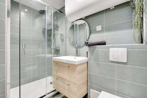 une salle de bain avec un lavabo et un miroir dans l'établissement Charming 1 Bedroom - Romainville 1, à Bagnolet
