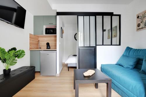 un salon avec un canapé bleu et une table dans l'établissement Charming 1 Bedroom with Sauna - Romainville 2, à Bagnolet