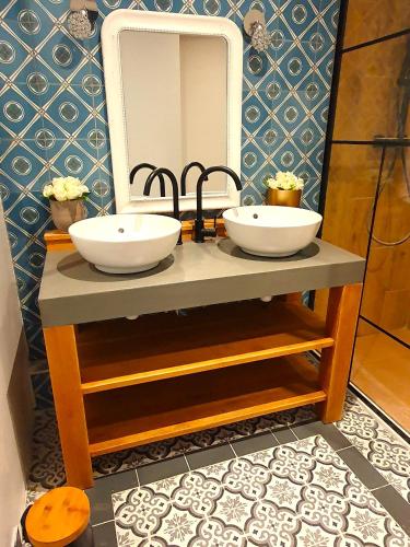 une salle de bain avec deux lavabos et un miroir dans l'établissement Le Clos du Mesnielle, à Ochancourt