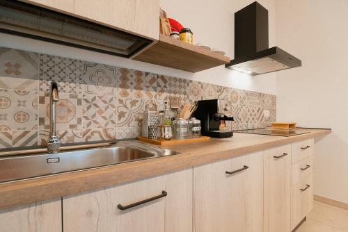 a kitchen with a stainless steel sink and wooden cabinets at Fattoria Cerqua Rooms and more in Montegranaro
